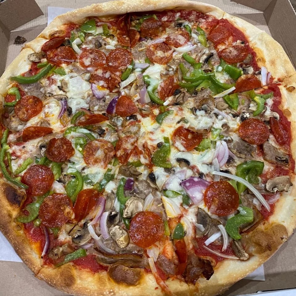 Tuscana Pizza & Pasta's pepperoni, mushroom, green pepper, and onion pizza in a delivery box.